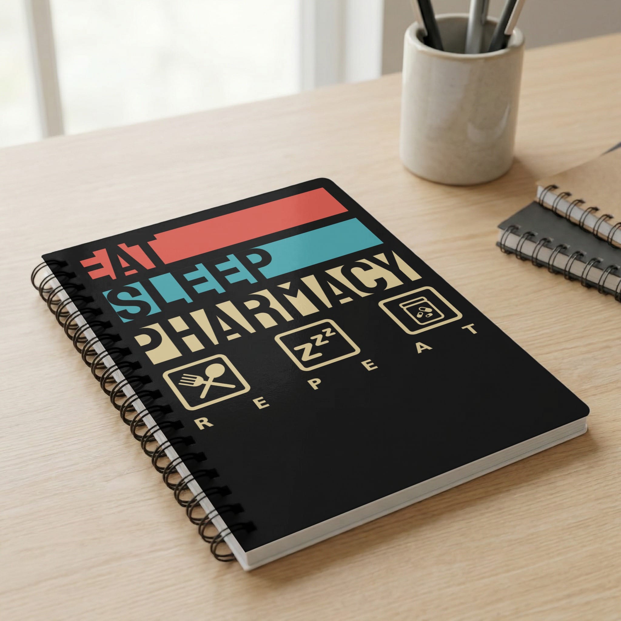 Spiral notebook with "Eat Sleep Pharmacy Repeat" text and icons.