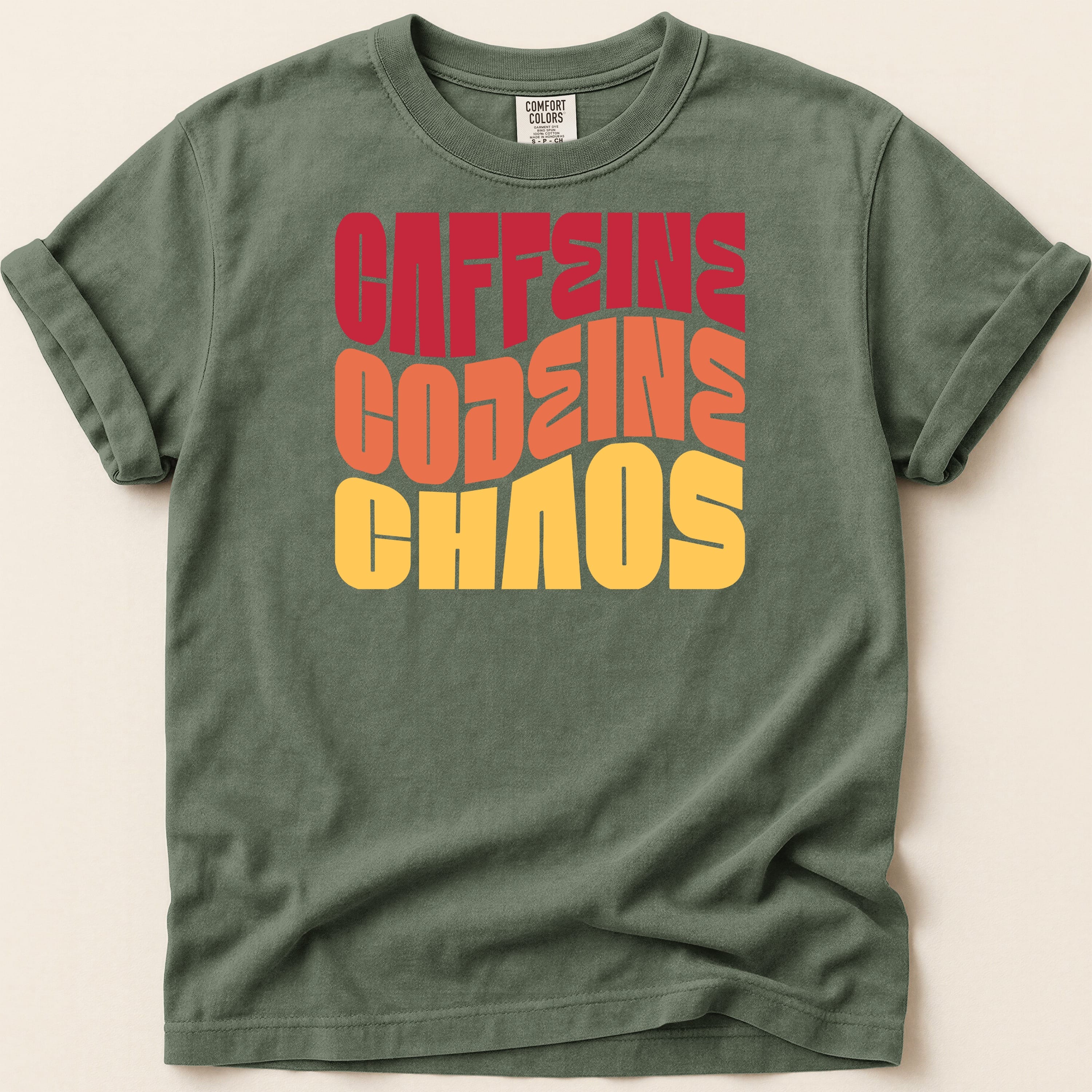 Green t-shirt with "CAFFEINE CODEINE CHAOS" in bold, colorful retro lettering.