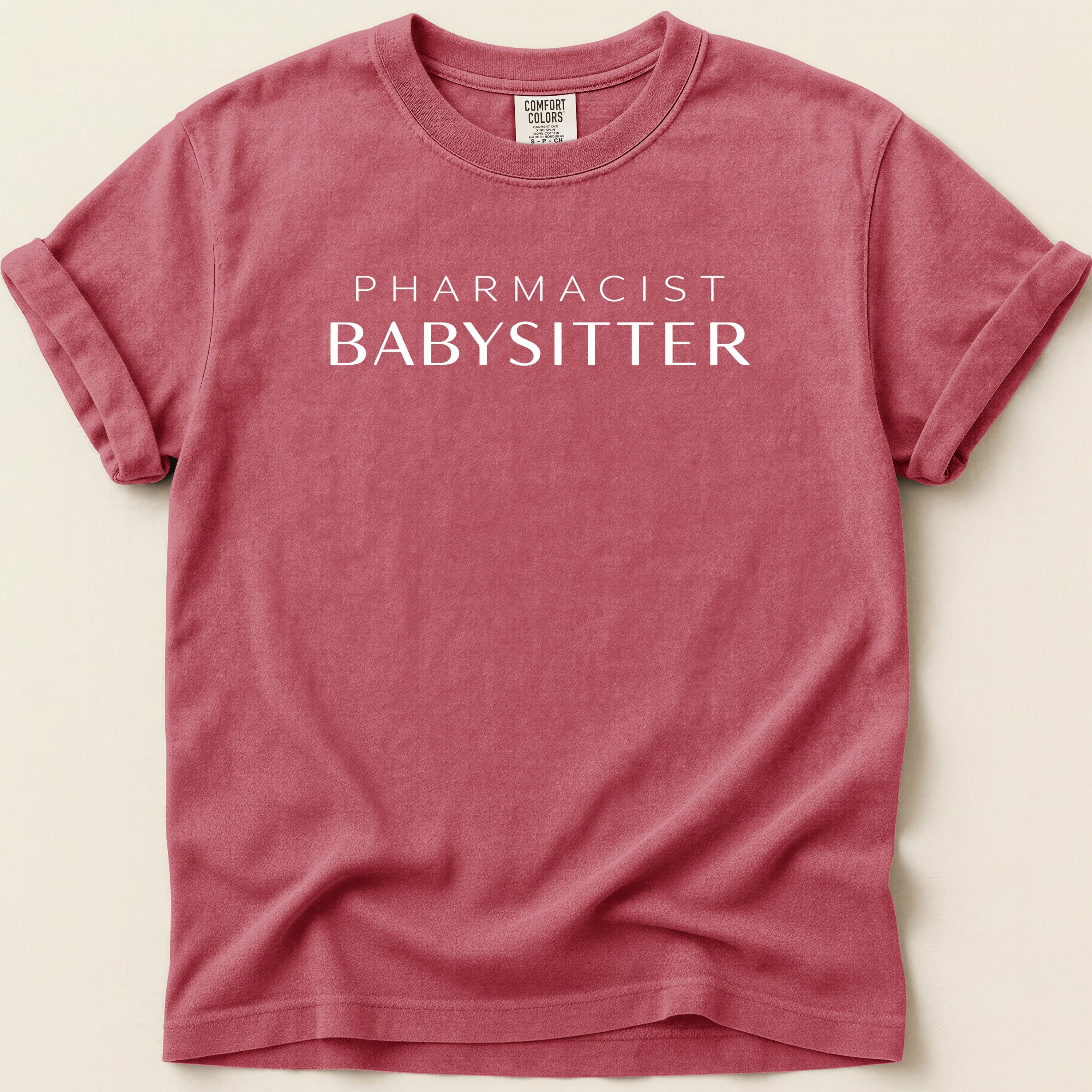 Red Comfort Colors t-shirt with "PHARMACIST BABYSITTER" printed in white.
