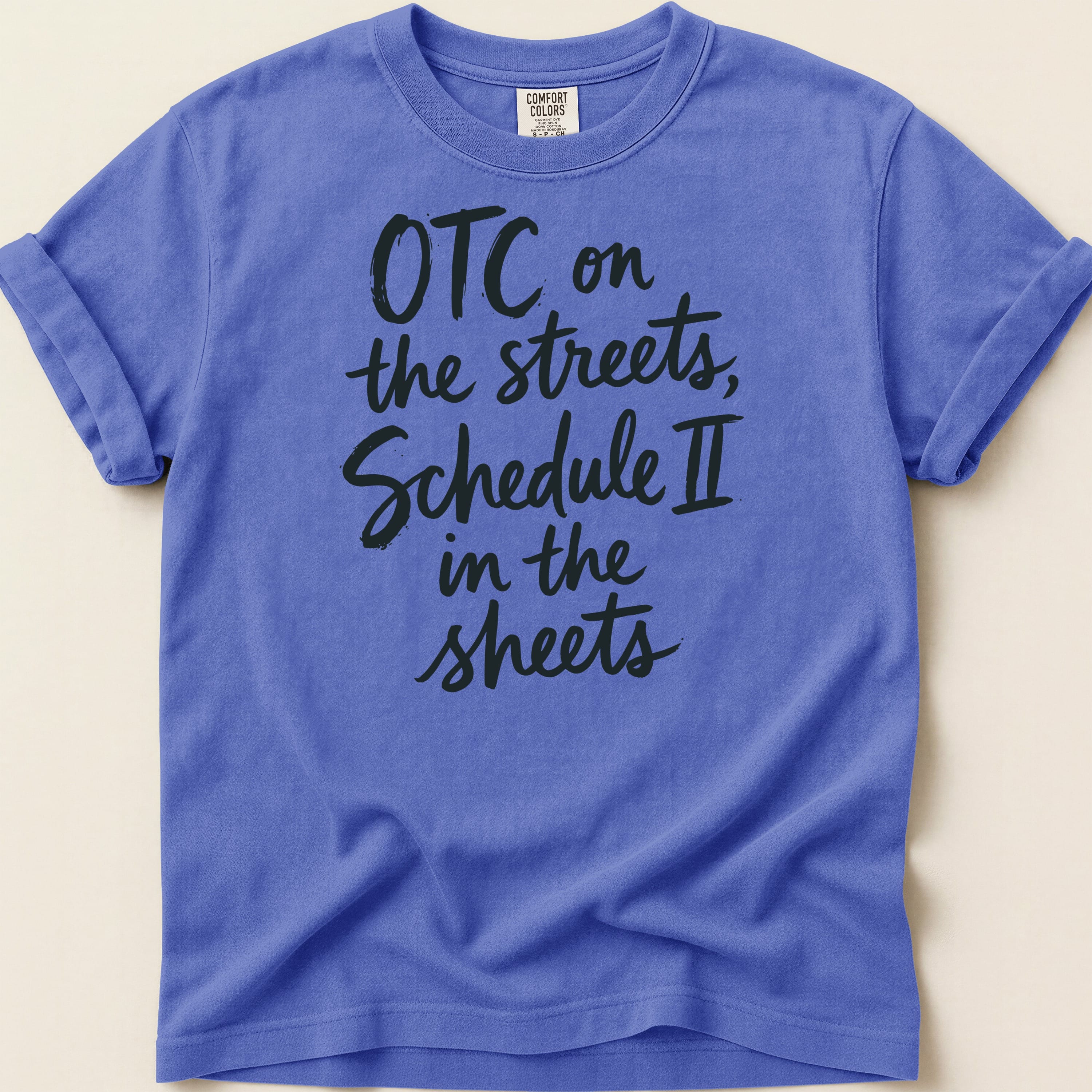 Purple t-shirt with "OTC on the streets, Schedule II in the sheets" in black script.