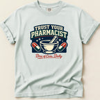 Light blue t-shirt with "Trust Your Pharmacist Dose of Care, Daily" graphic.