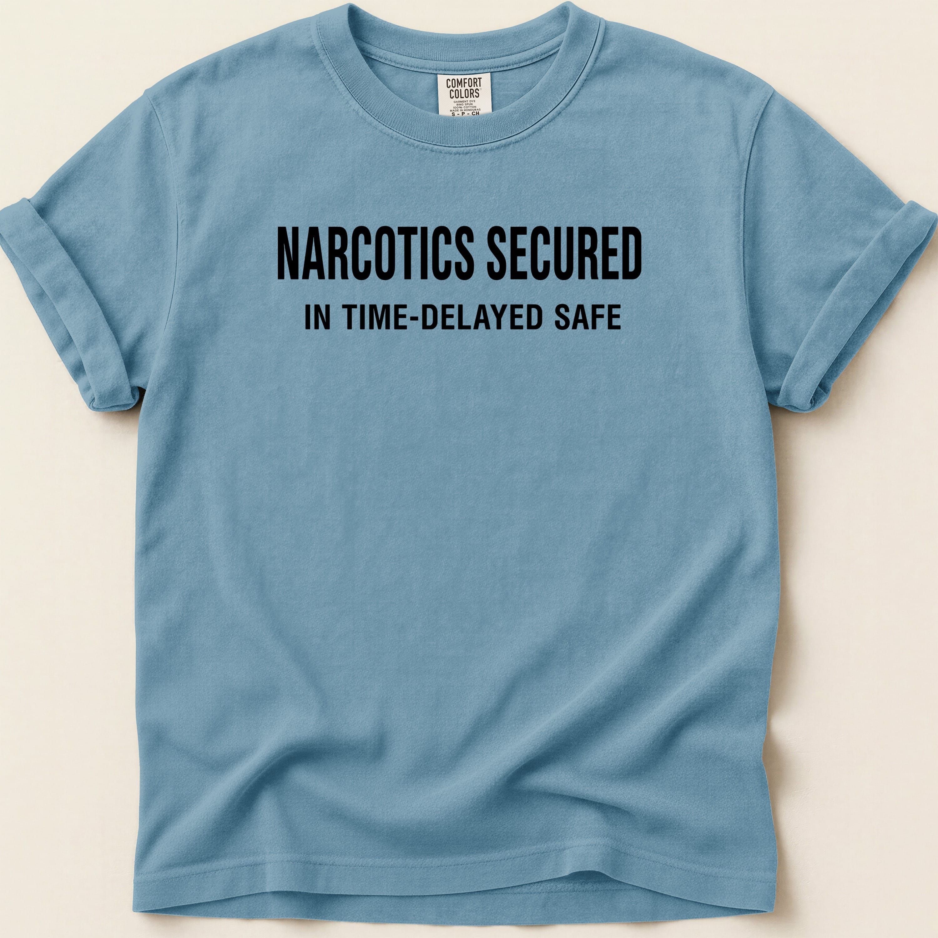 Blue t-shirt with "NARCOTICS SECURED IN TIME-DELAYED SAFE" text.