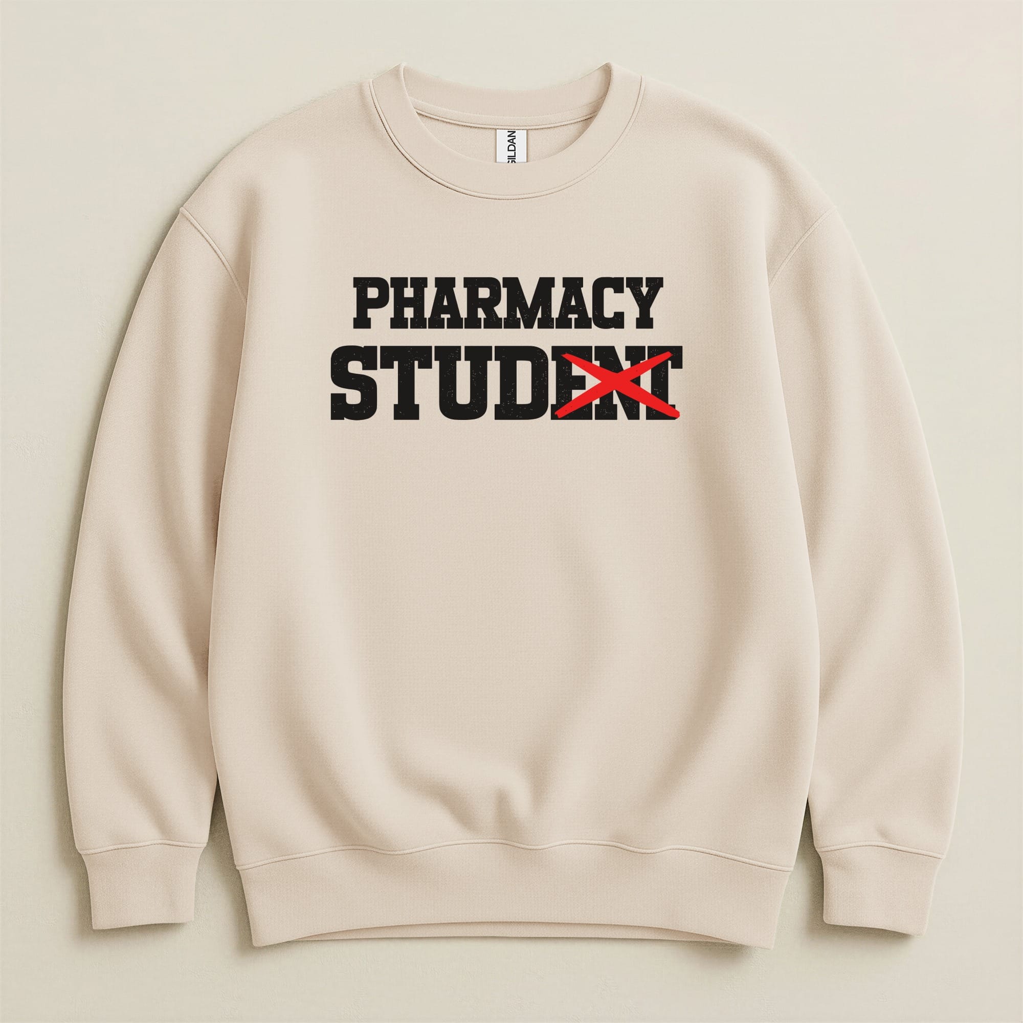 Beige sweatshirt with "PHARMACY STUDENT" printed in black with red tape over "STUDENT".
