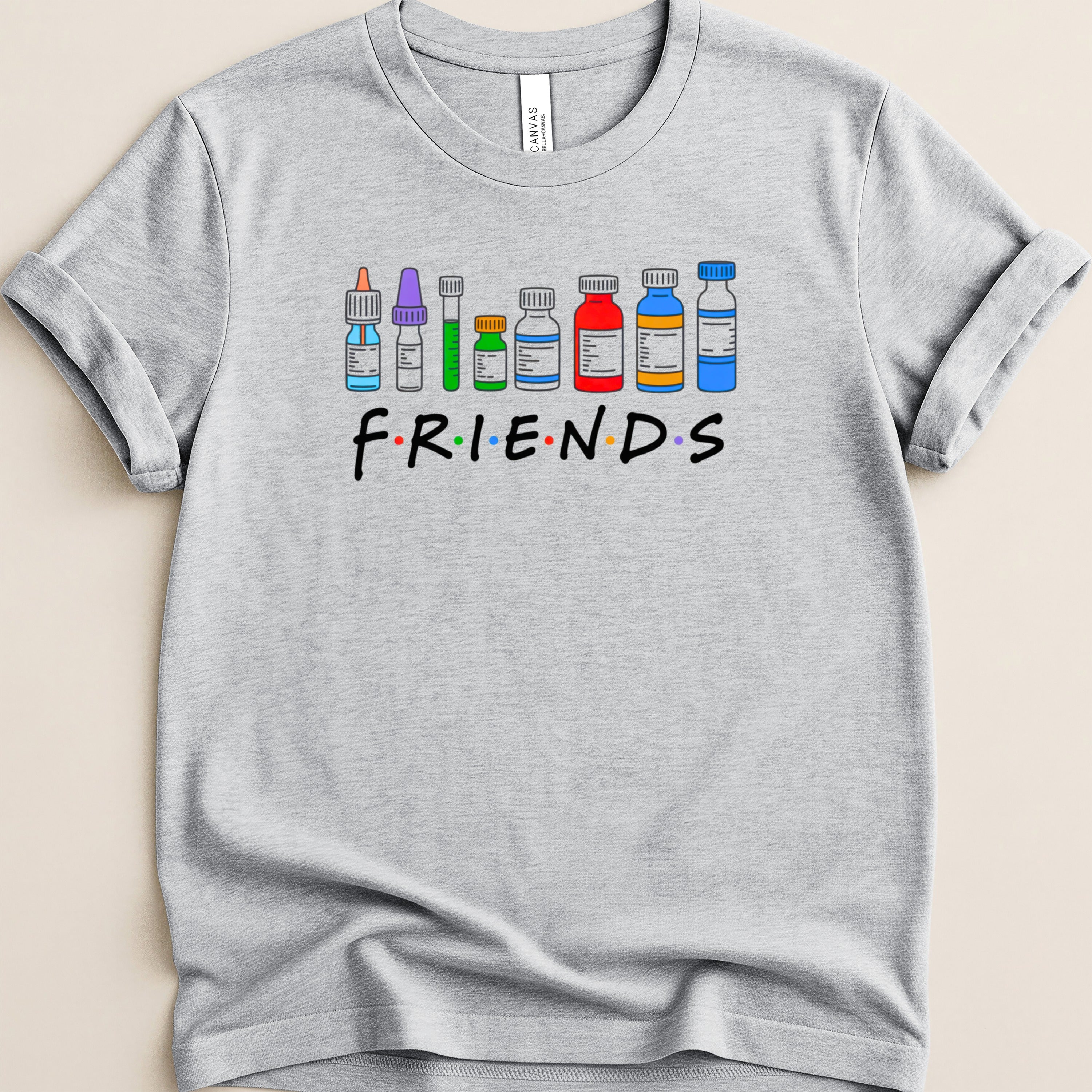 Grey t-shirt with "FRIENDS" text and cartoon medical vials.