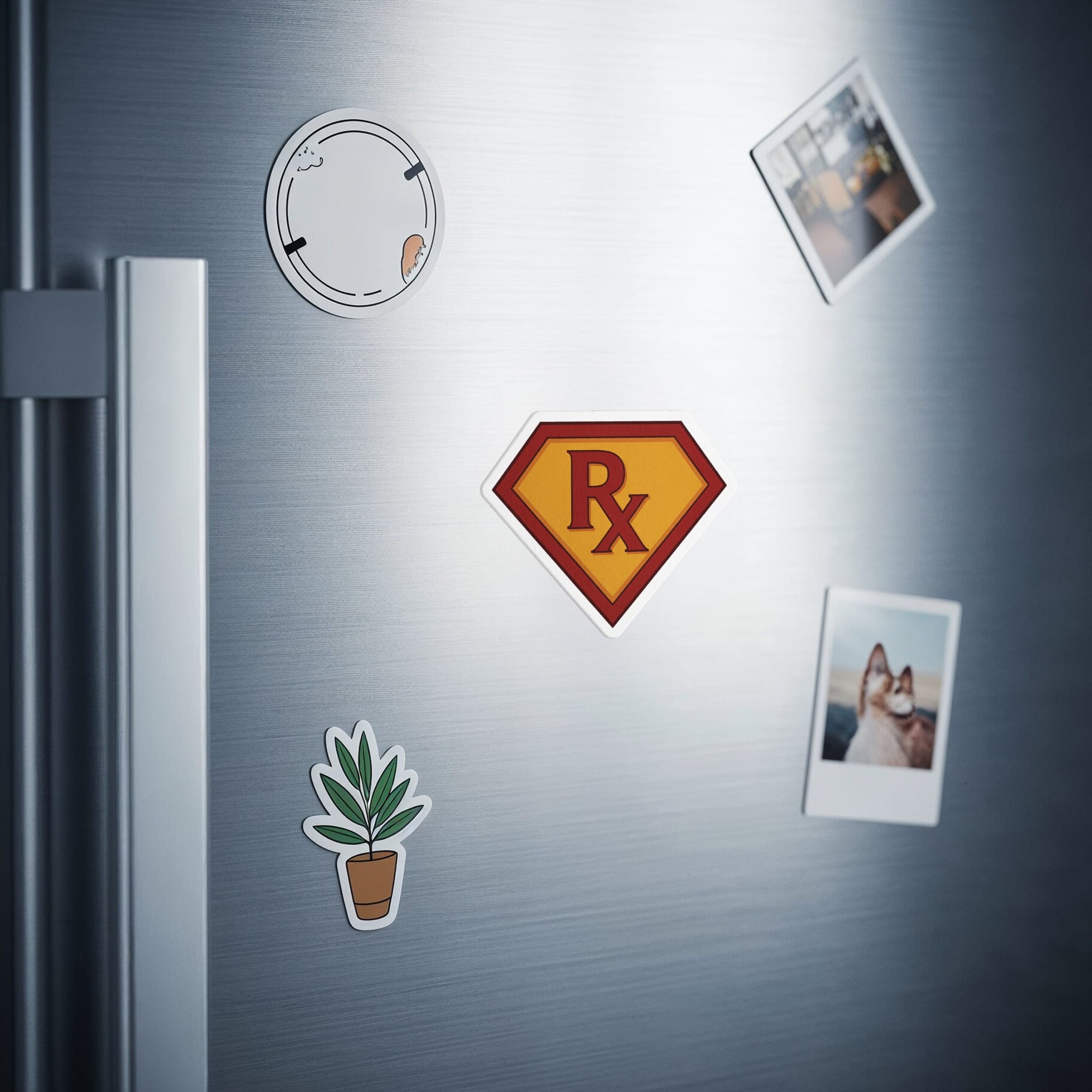 Super R-X symbol magnet and framed photos on a stainless steel refrigerator door.