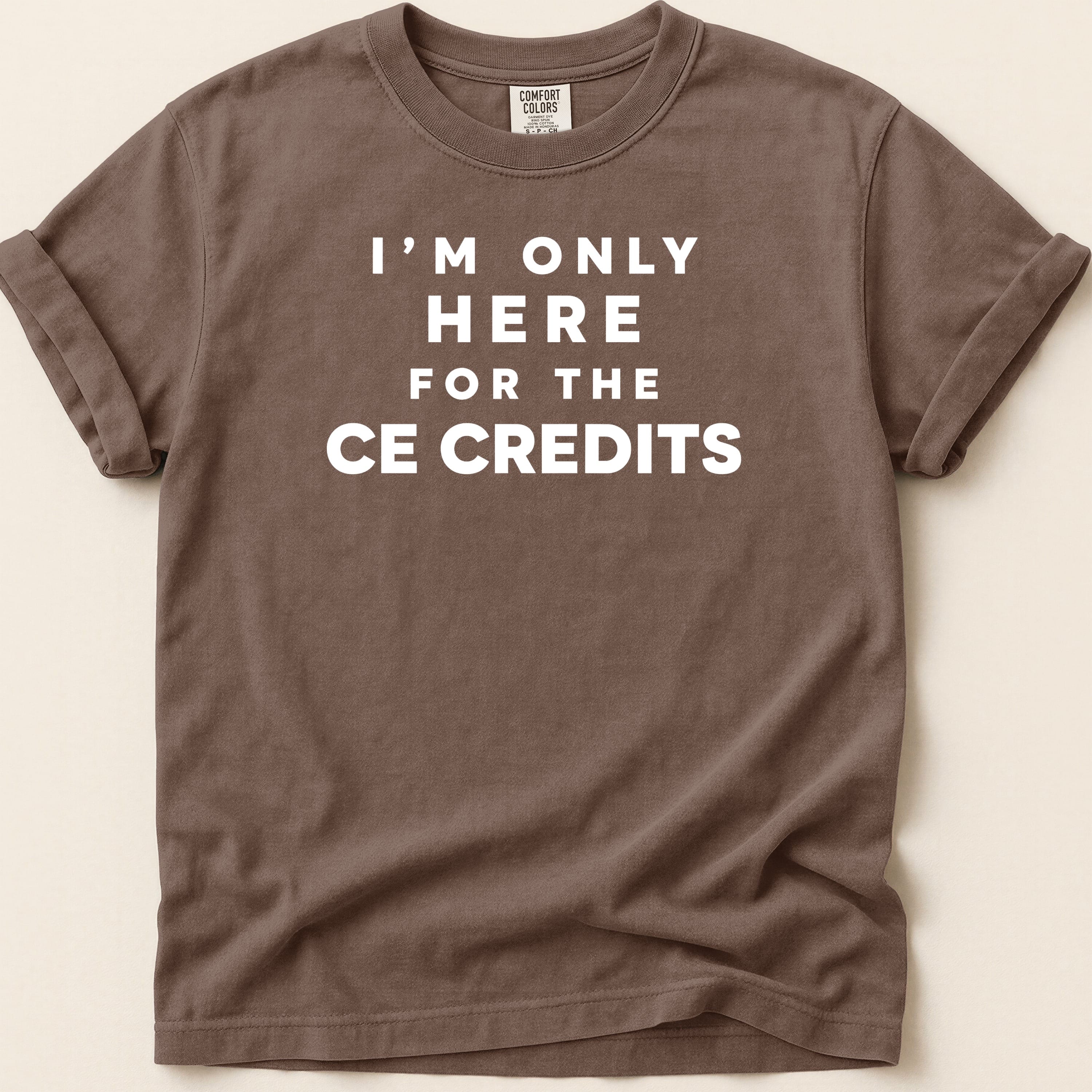 Brown t-shirt with white text "I'M ONLY HERE FOR THE CE CREDITS".