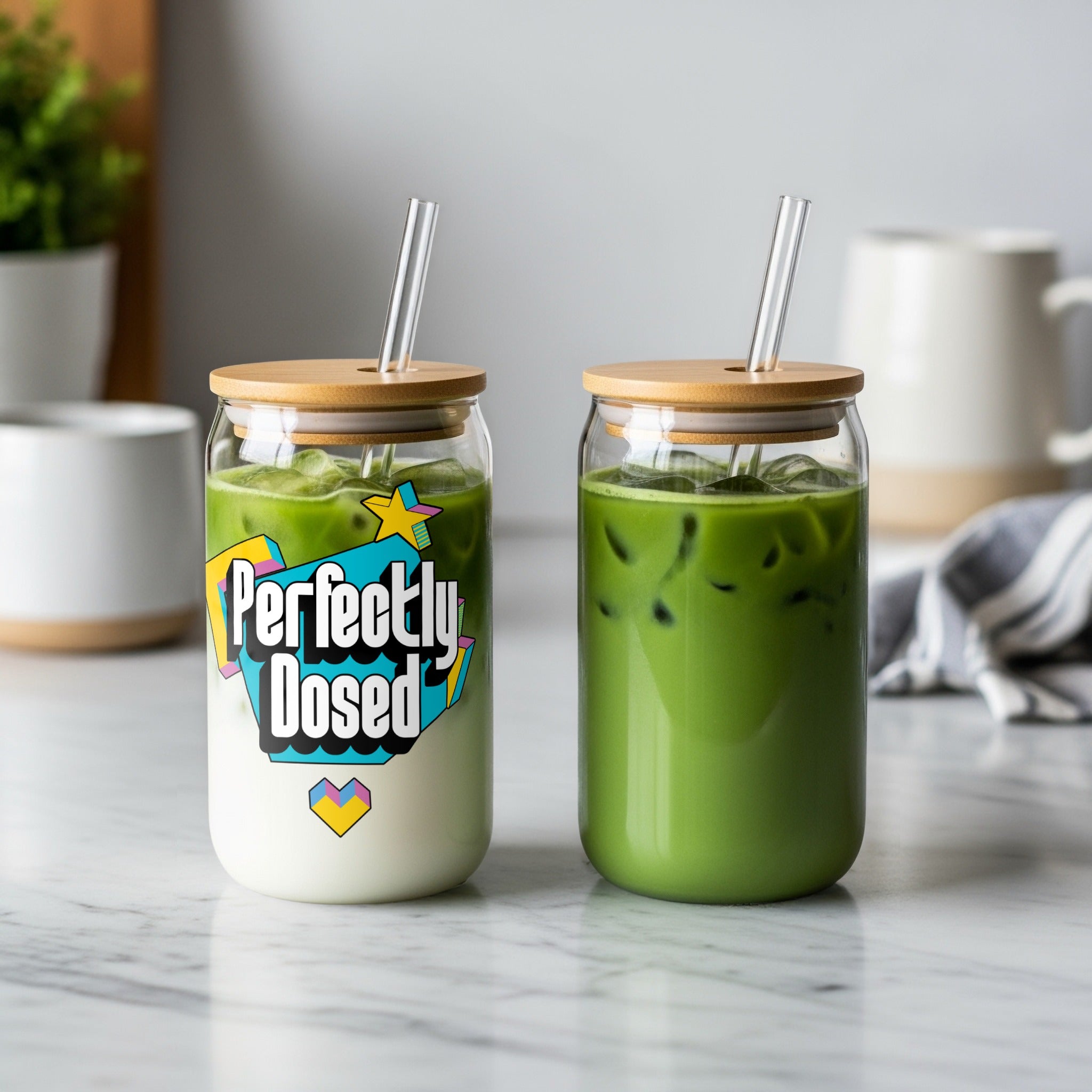 Two iced matcha lattes in glass cups with bamboo lids and straws.
