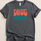 Dark t-shirt with "DRUG EXPERT" in distressed orange and teal lettering.