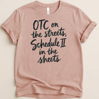 Pink t-shirt with black text reading "OTC on the streets, Schedule II in the sheets".
