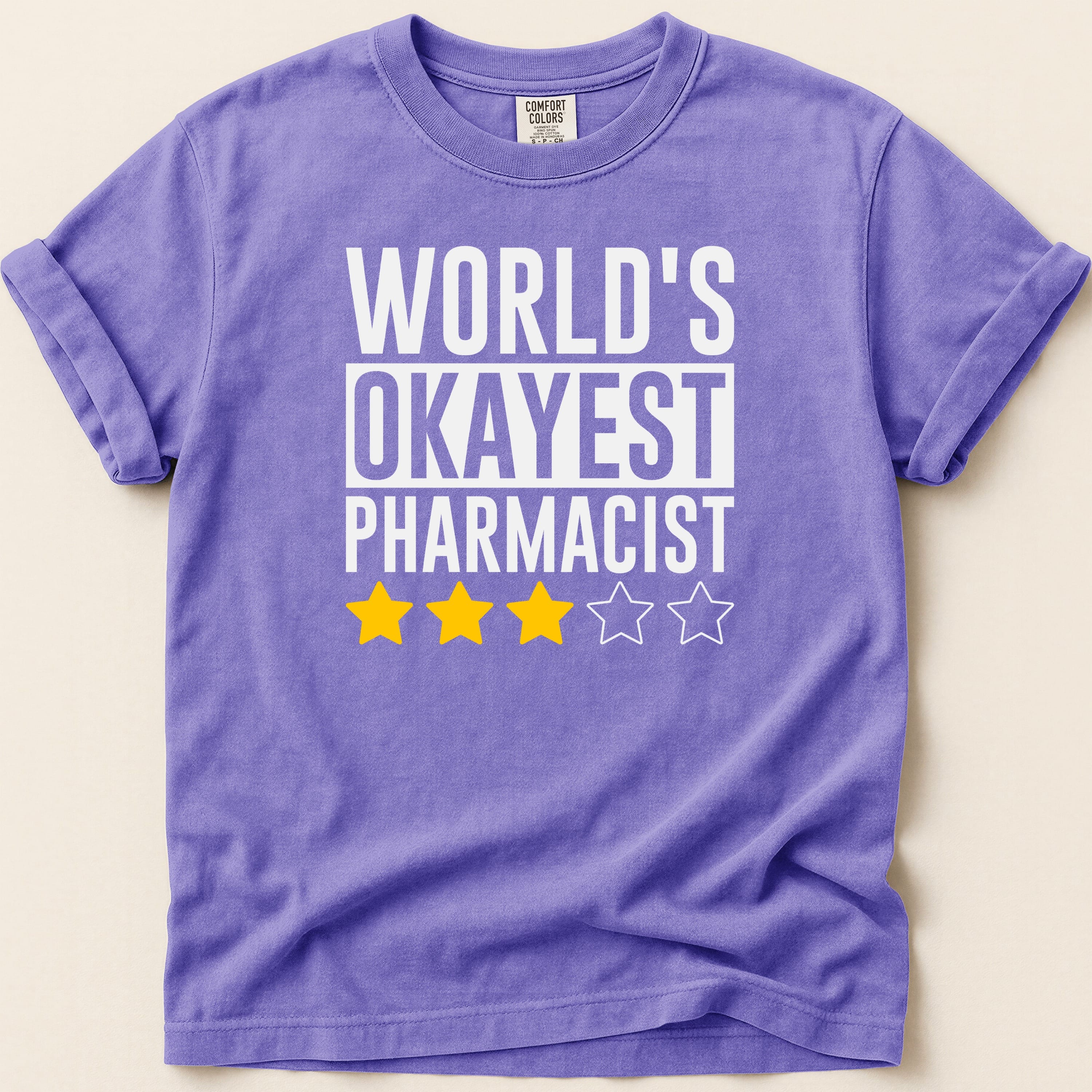 Purple t-shirt with "World's Okayest Pharmacist" and three yellow stars.