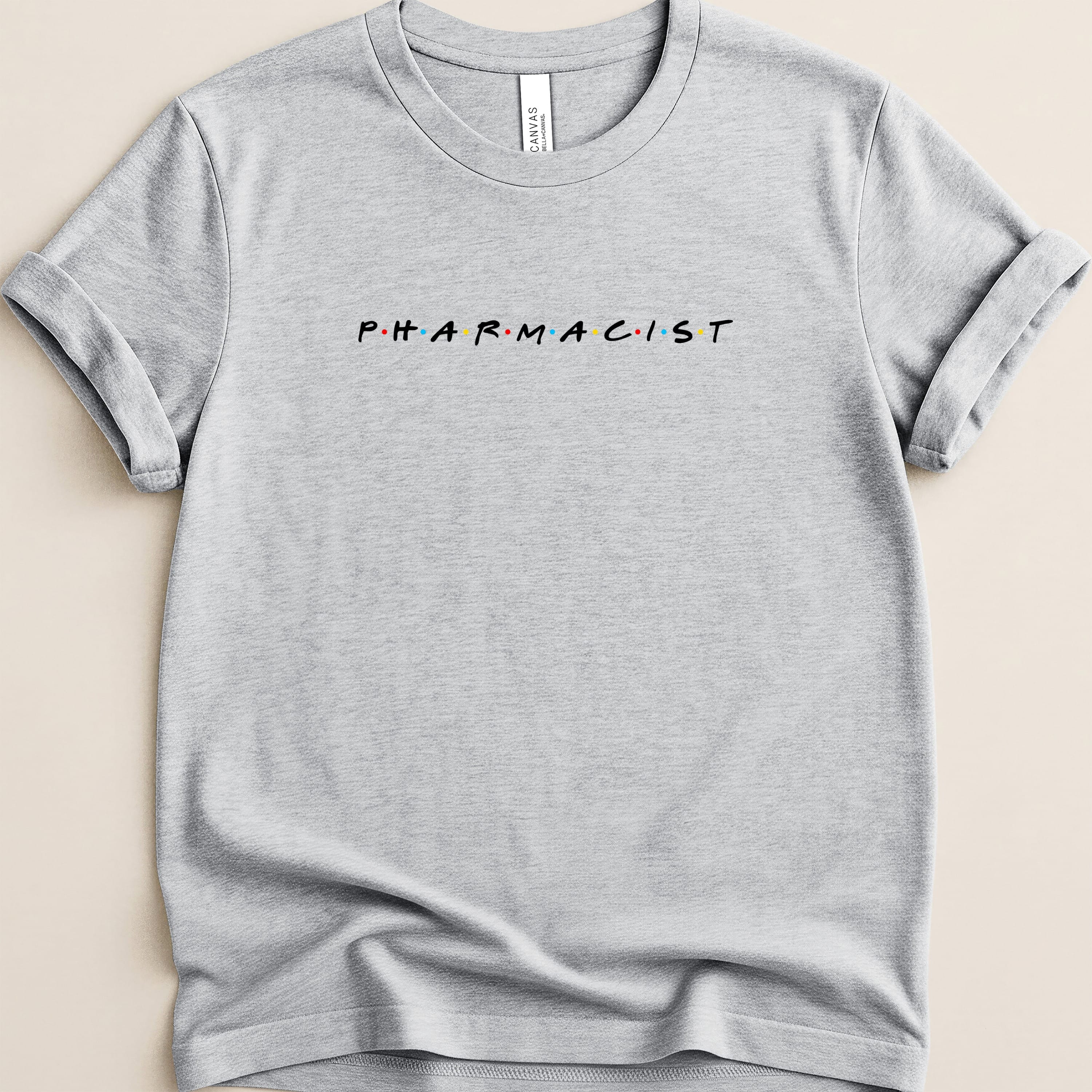 Grey t-shirt with "PHARMACIST" in colorful, spaced-out block letters.