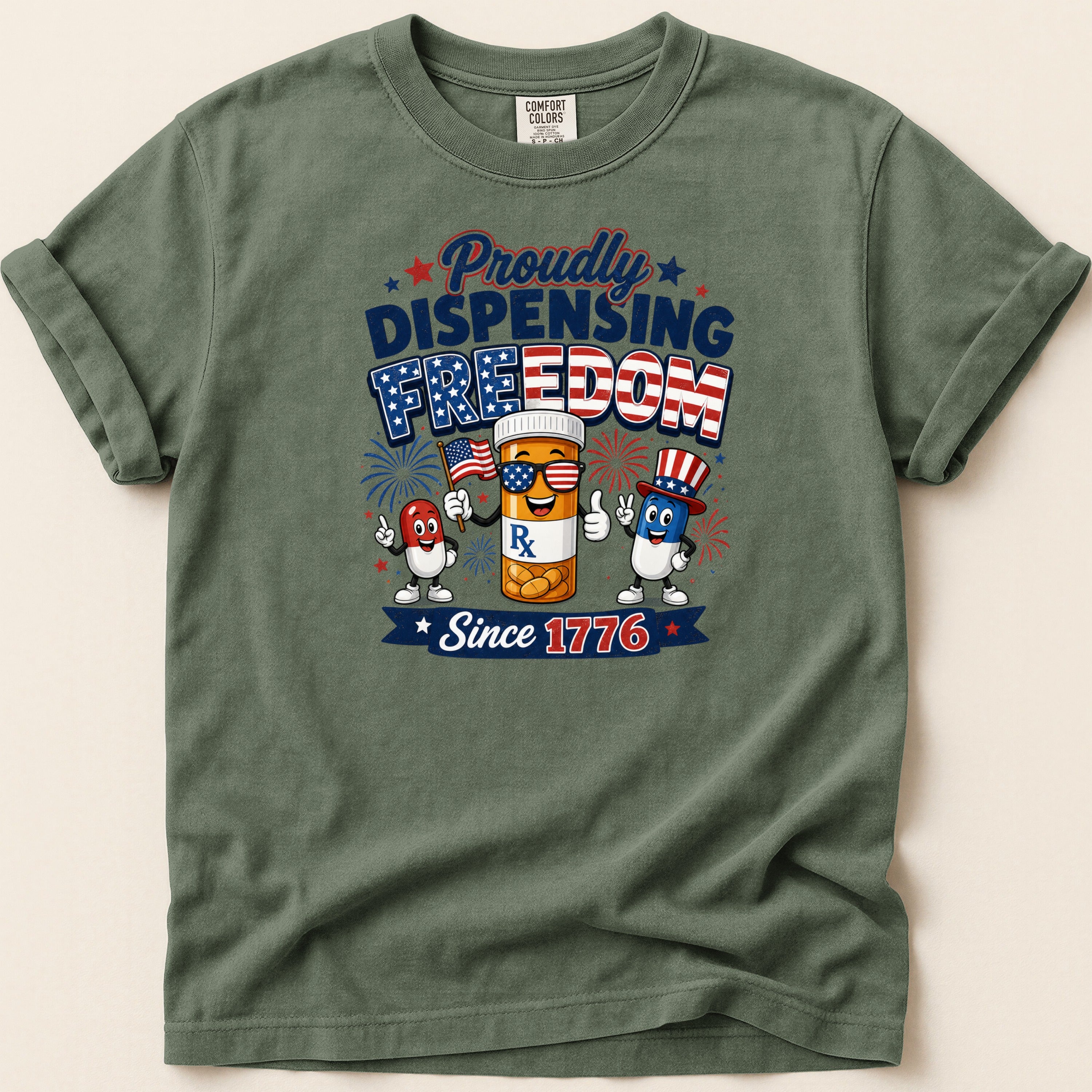 T-shirt with "Proudly Dispensing Freedom Since 1776" text and patriotic pill characters.