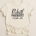 Cream t-shirt with "Retired Pharmacist" text and pill graphic.