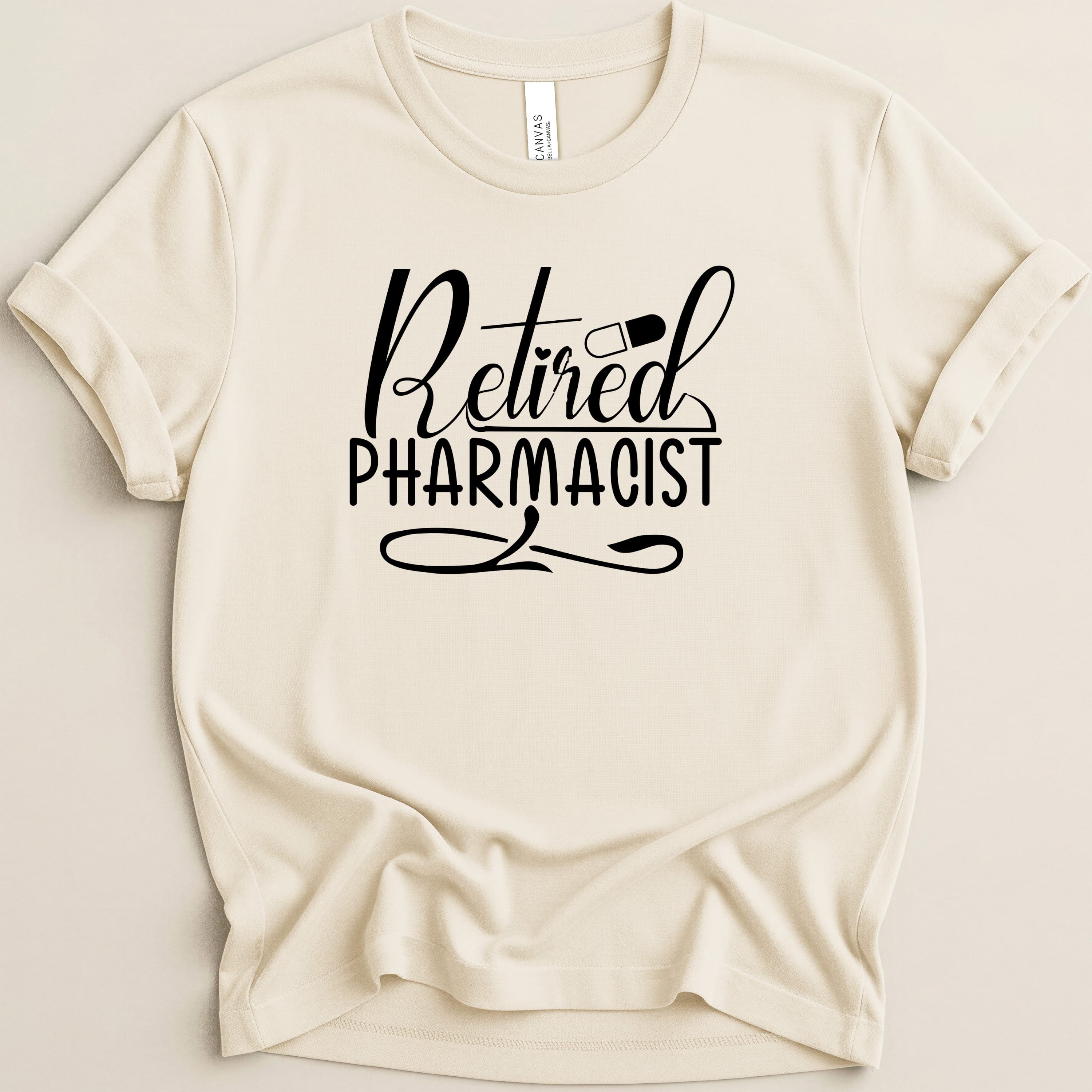 Cream t-shirt with "Retired Pharmacist" text and pill graphic.