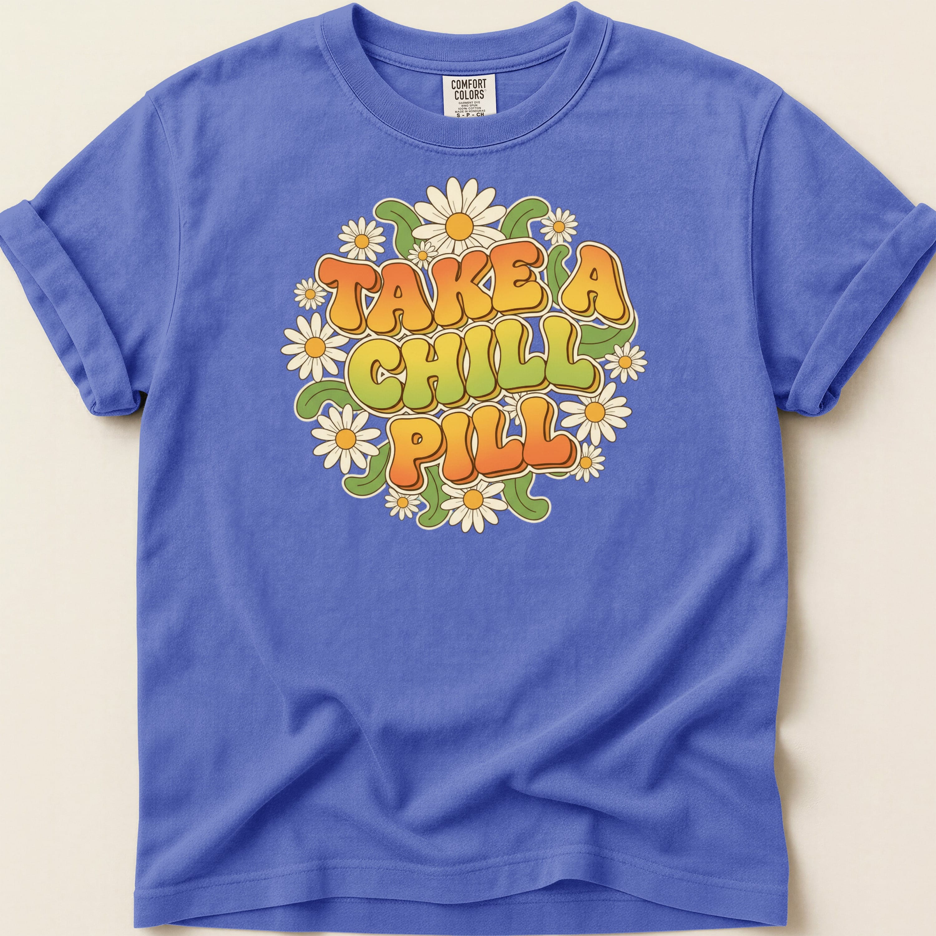 T-shirt with "TAKE A CHILL PILL" text surrounded by daisies.