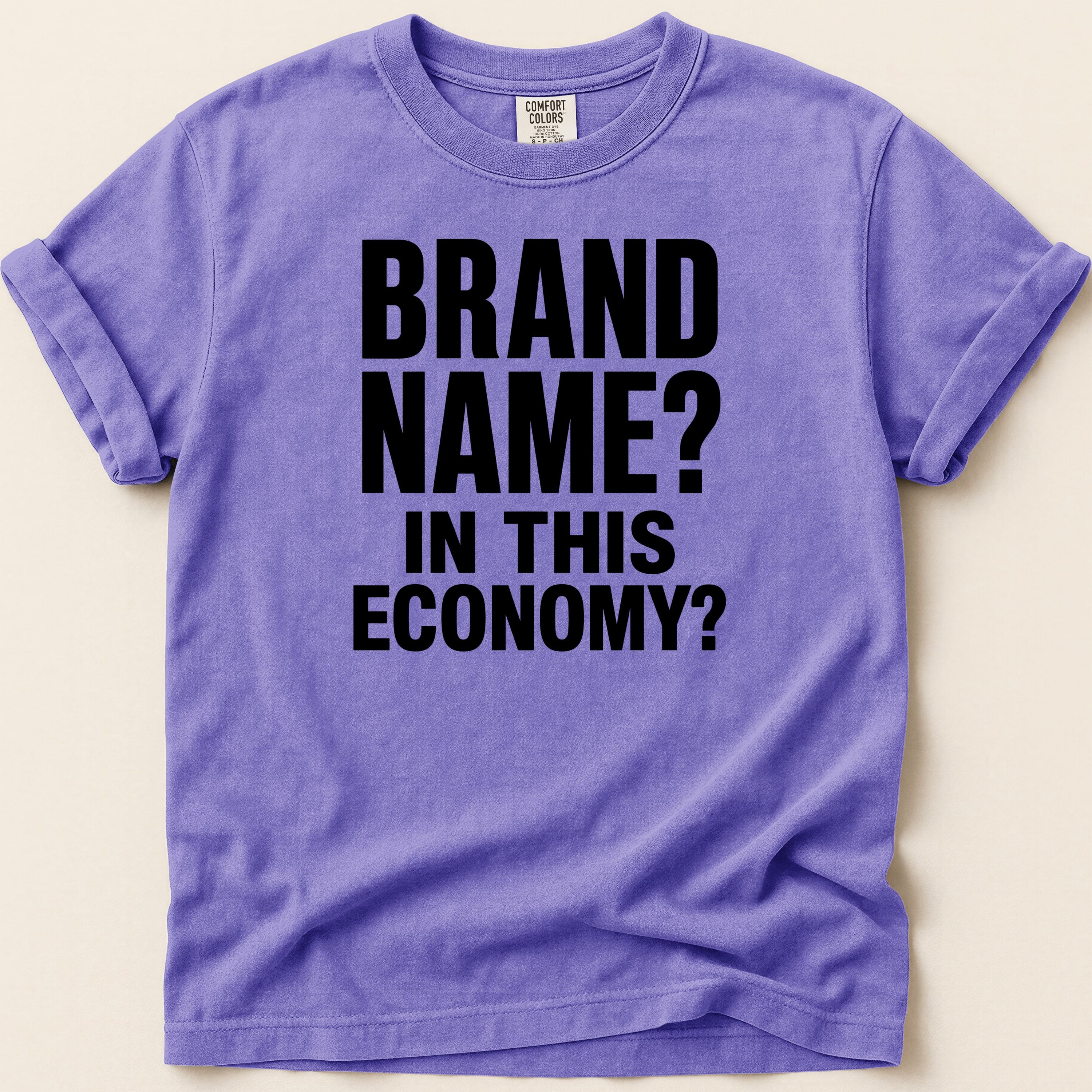 Purple t-shirt with "BRAND NAME? IN THIS ECONOMY?" text.