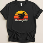 Black t-shirt with a sunset graphic featuring a mortar and pestle and the text "Pharmacy Life".