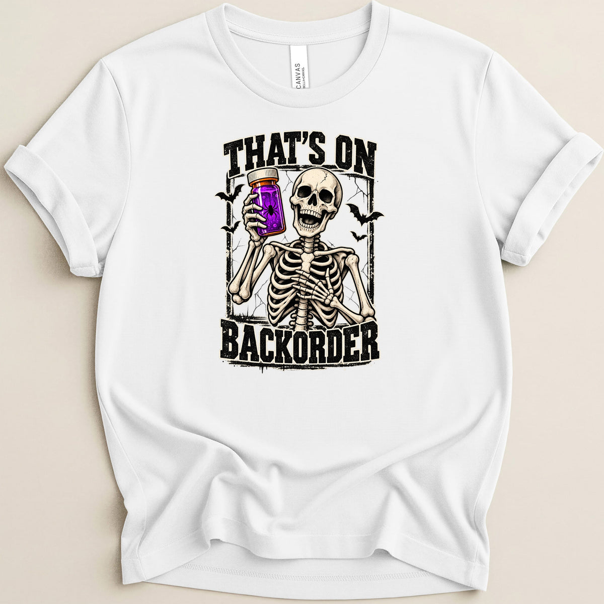 White t-shirt with skeleton holding purple potion jar, text "That's on backorder".