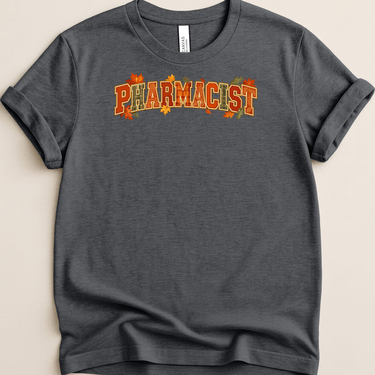 Dark gray t-shirt with rolled sleeves featuring the word PHARMACIST in orange and autumn leaf patterns.
