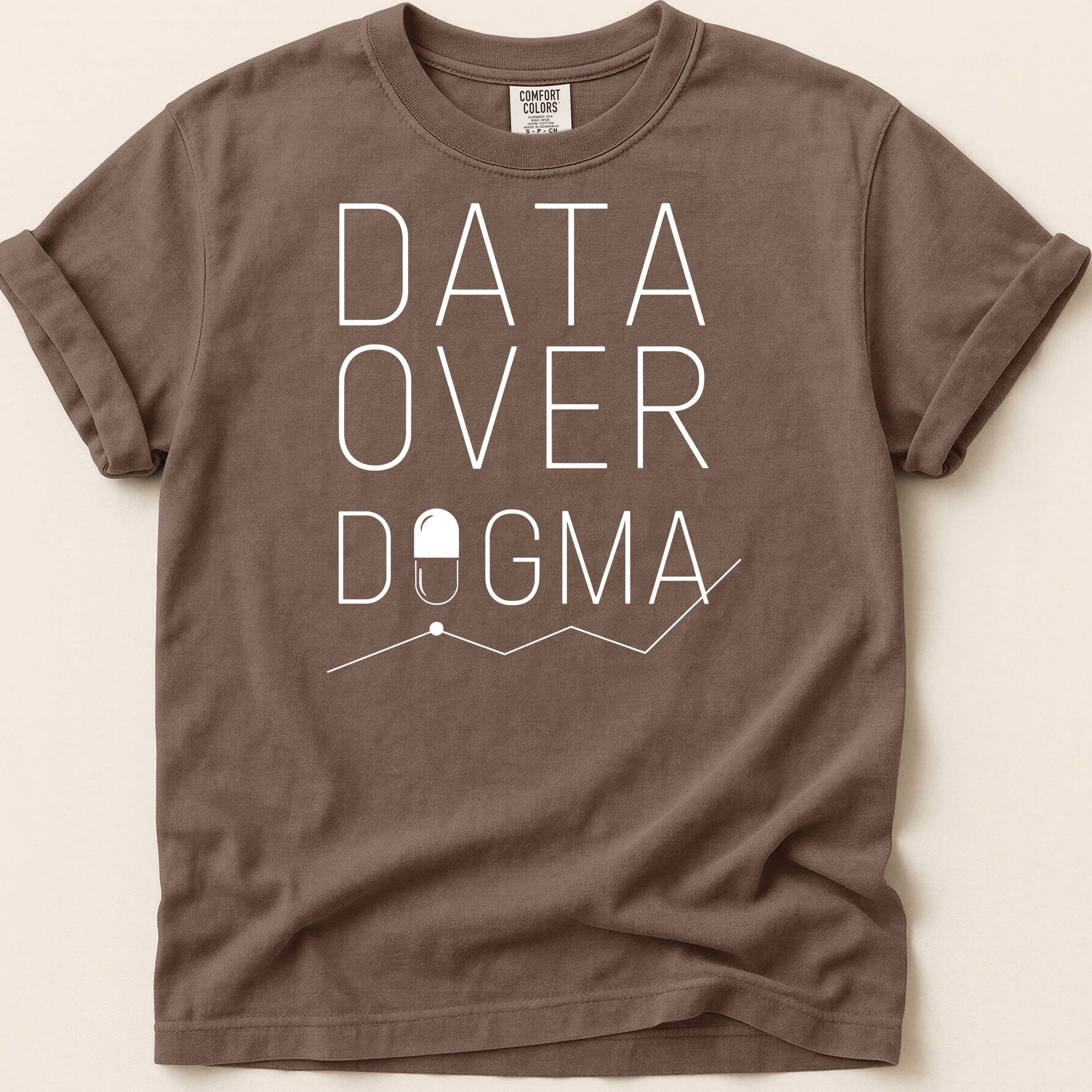 Brown t-shirt with white text "DATA OVER DOGMA" and a pill graphic.