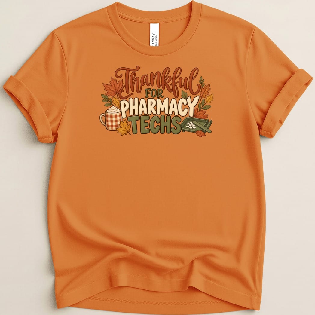 Orange crewneck t-shirt featuring a fall-themed graphic that reads Thankful for Pharmacy Techs.