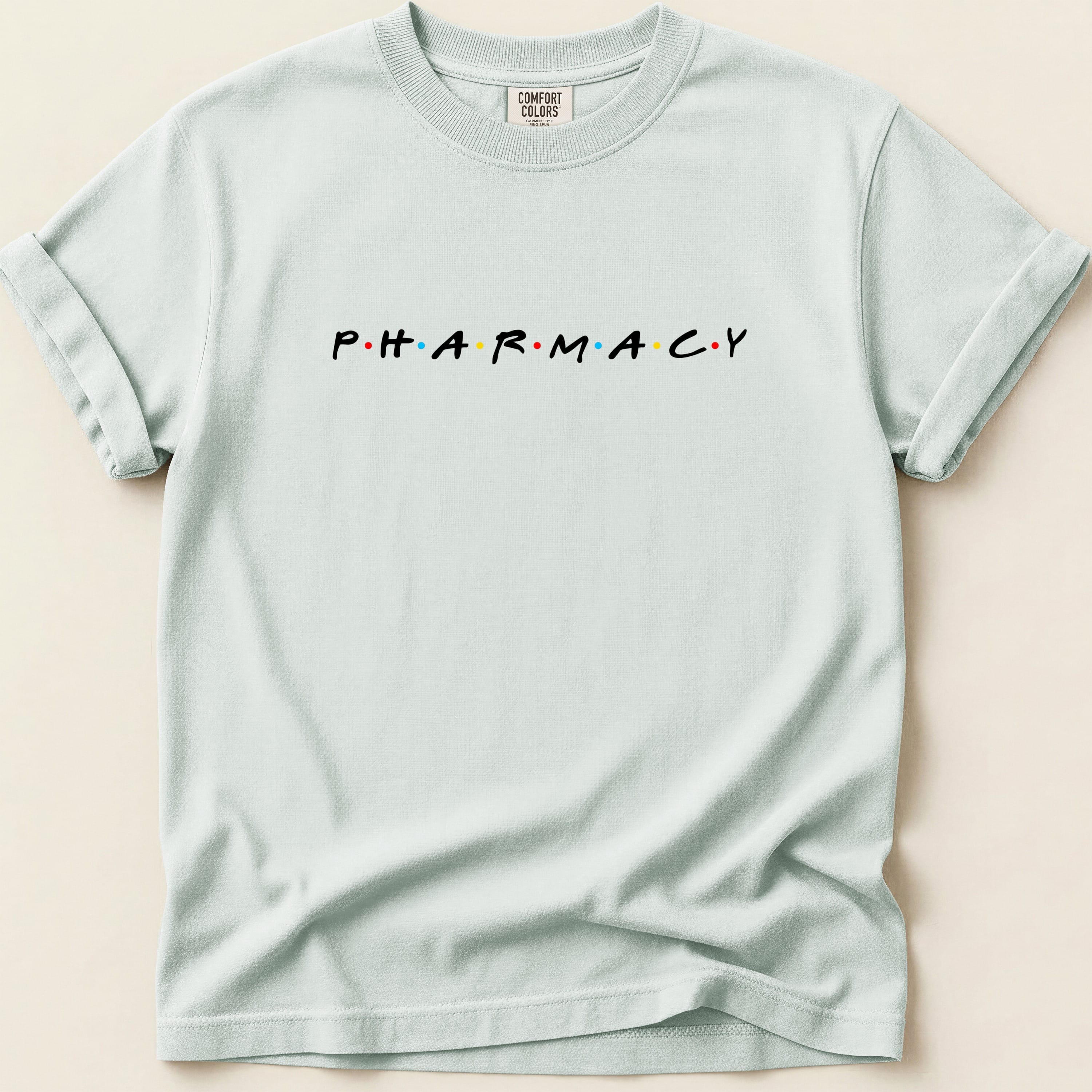 Light blue t-shirt with "PHARMACY" in colored dot letters.