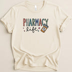 Cream t-shirt with colorful "Pharmacy Life" text and pill bottle graphic.