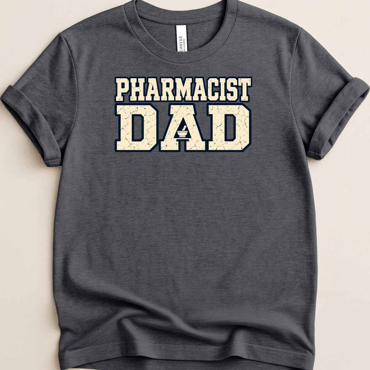 A dark grey crewneck t-shirt with rolled sleeves featuring the text PHARMACIST DAD in distressed block letters.