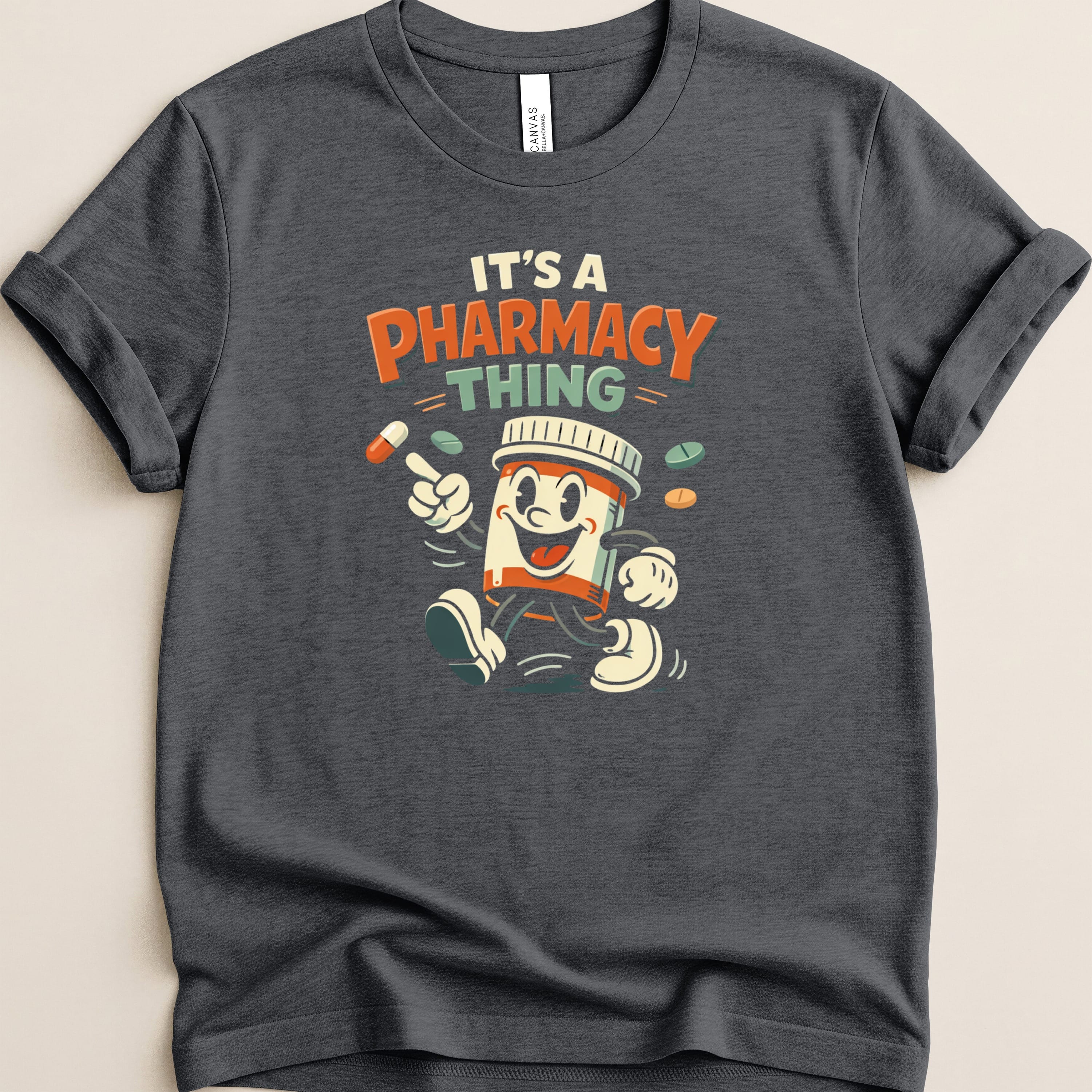 Dark gray t-shirt with "It's a Pharmacy Thing" and cartoon pill bottle.