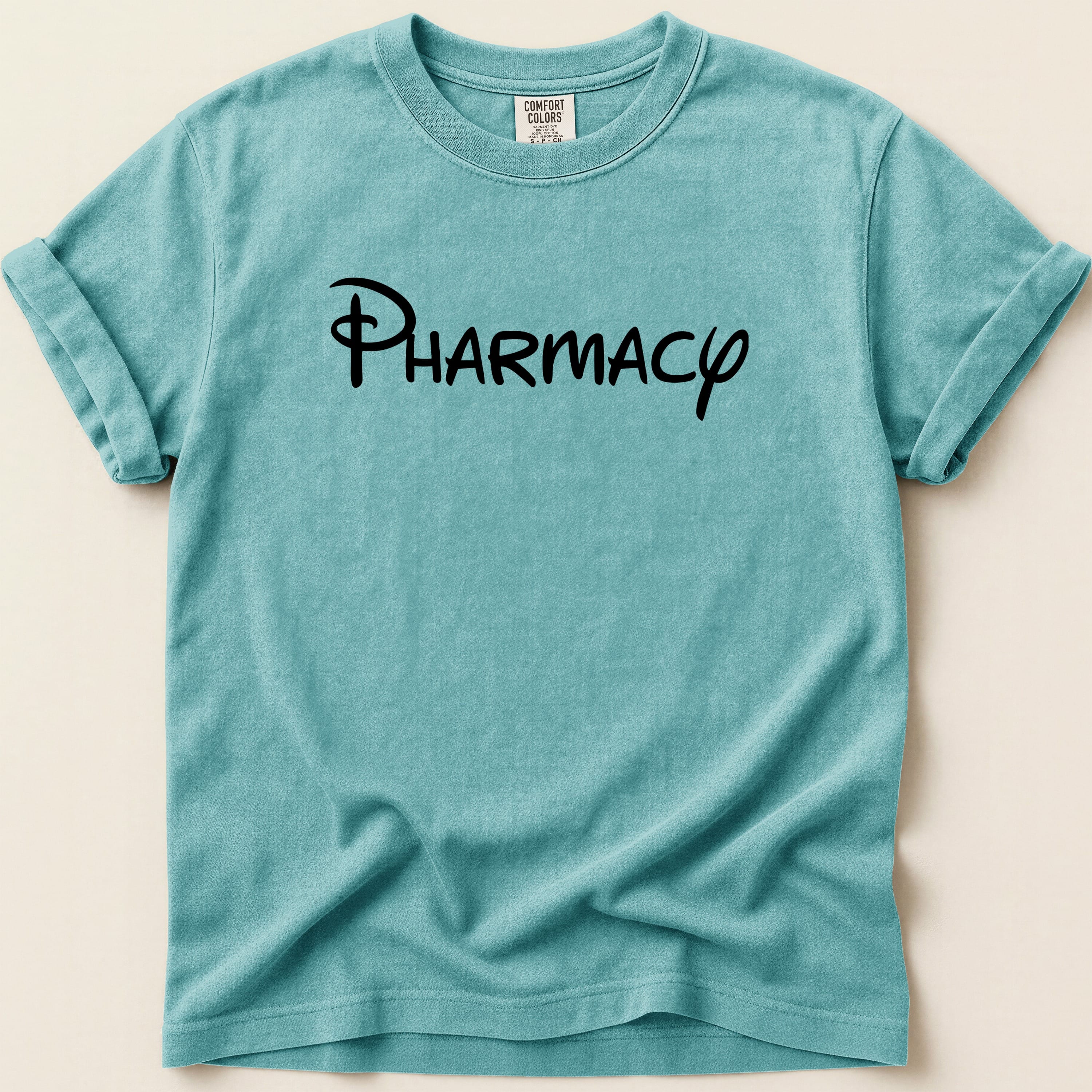 Teal t-shirt with "Pharmacy" in black Disney-style script.