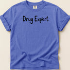 Purple t-shirt with "Drug Expert" text in black spray paint font.