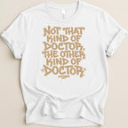 White t-shirt with tan text reading "Not that kind of doctor, the other kind of doctor".