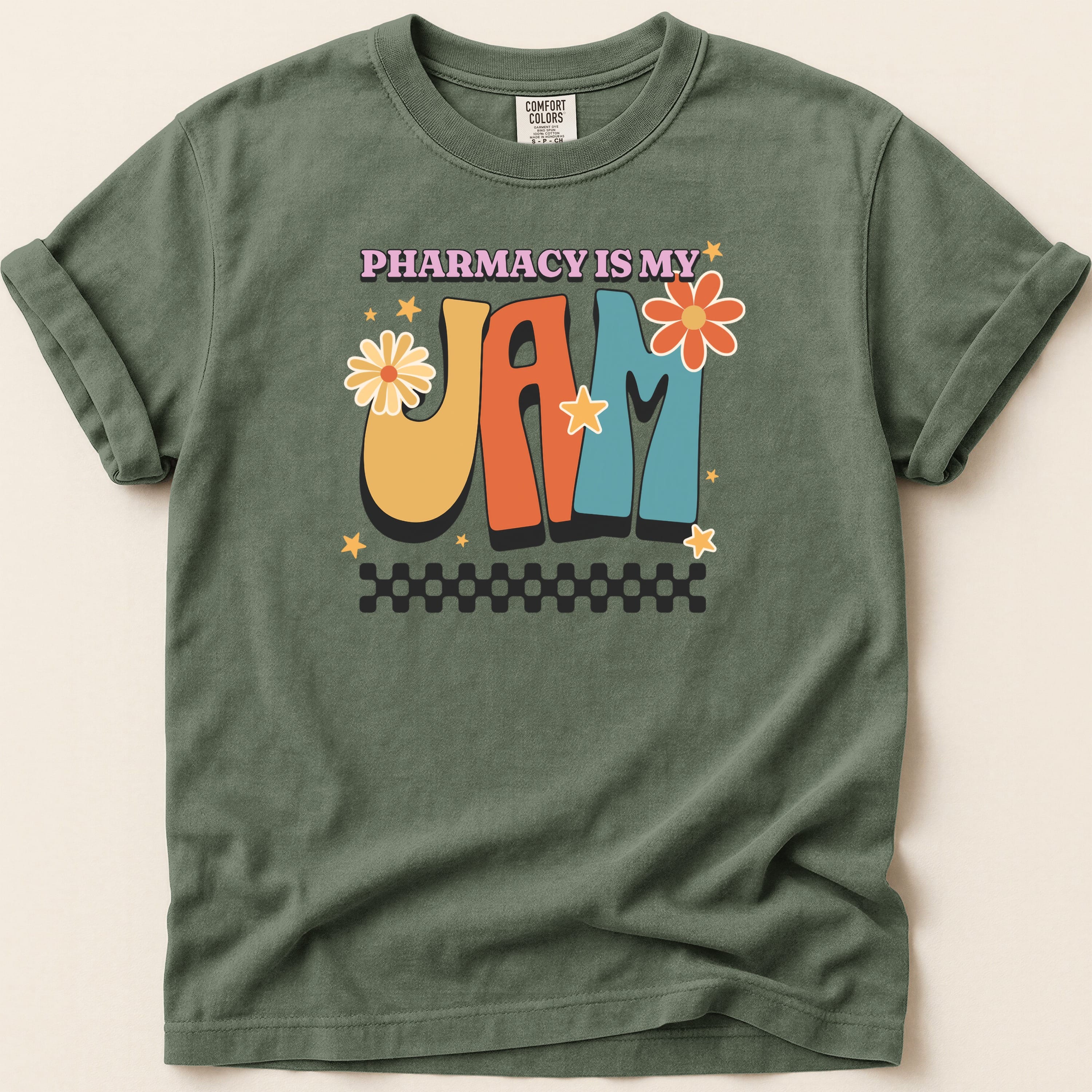 Green t-shirt with "Pharmacy is my Jam" in colorful retro lettering and floral accents.