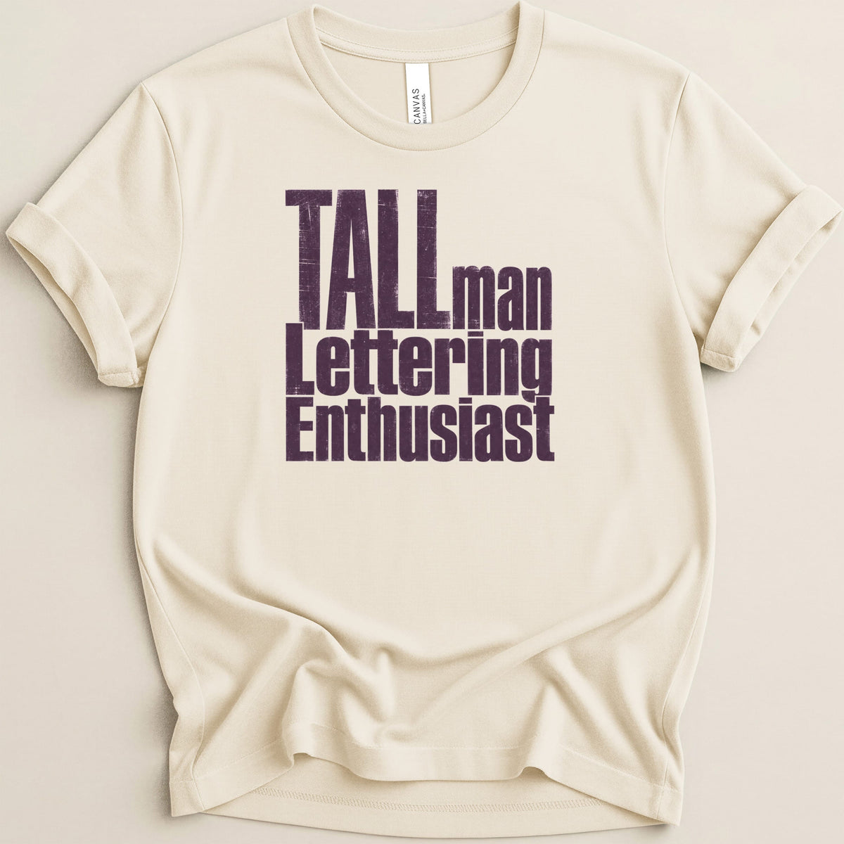 Cream t-shirt with "TALLman Lettering Enthusiast" text.