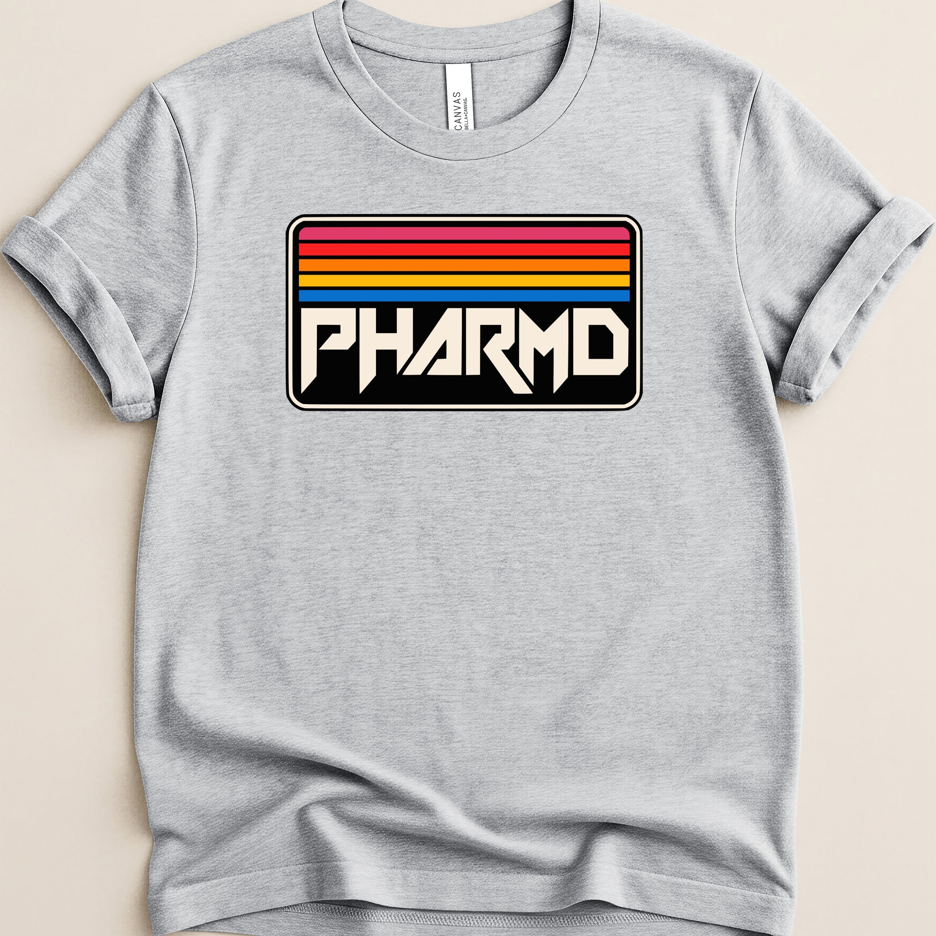 Light grey t-shirt with "PHARMD" in bold white letters on a black background with rainbow stripes.
