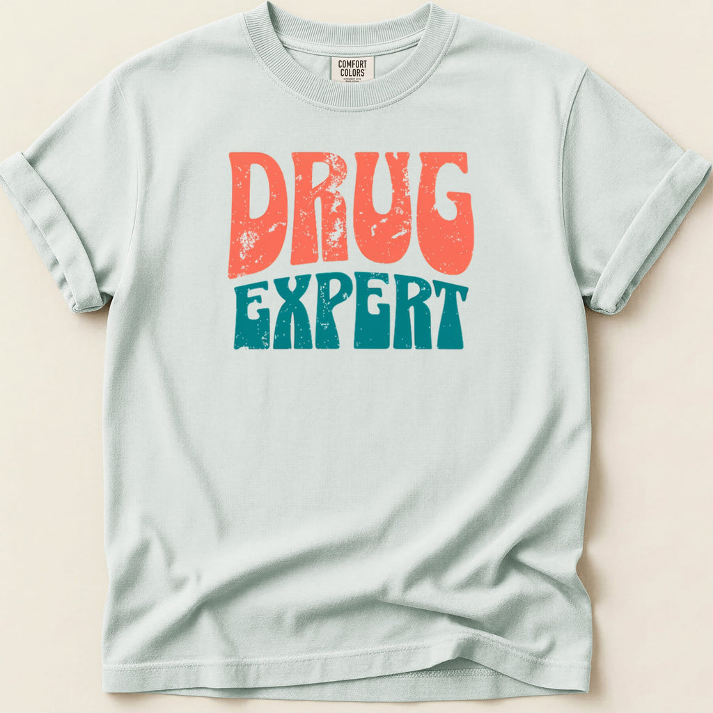 Light blue t-shirt with distressed "DRUG EXPERT" text in orange and teal.