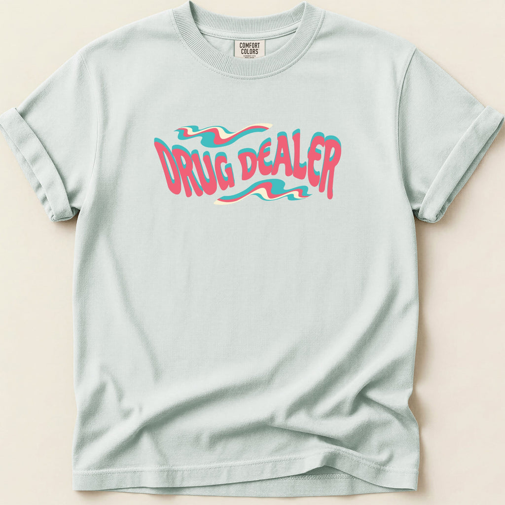 Light blue t-shirt with "DRUG DEALER" text in wavy pink and teal lettering.