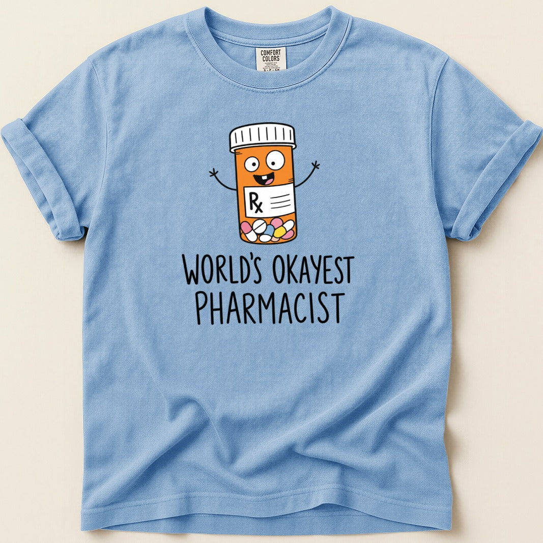 Light blue t-shirt with pill bottle graphic and text "WORLD'S OKAYEST PHARMACIST".