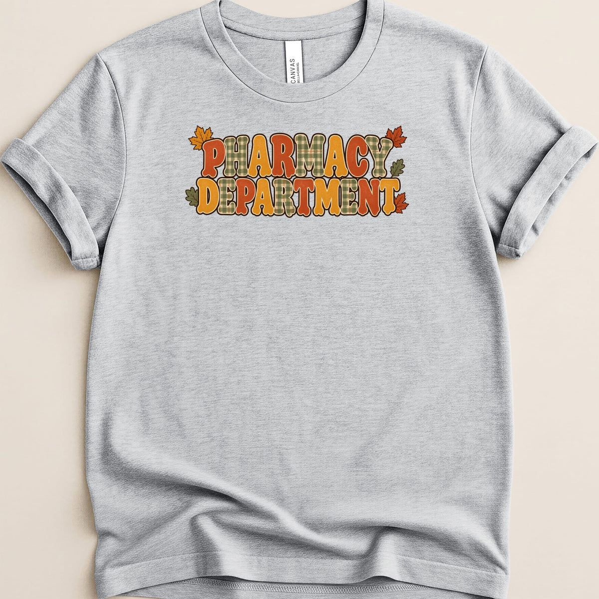 Heather grey t-shirt featuring a retro autumn-themed Pharmacy Department graphic with plaid letters and fall leaves.
