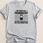 Gray t-shirt with text: "MY WIFE IS A PHARMACIST SHE HASN'T KILLED ME, YET BUT SHE KNOWS HOW".