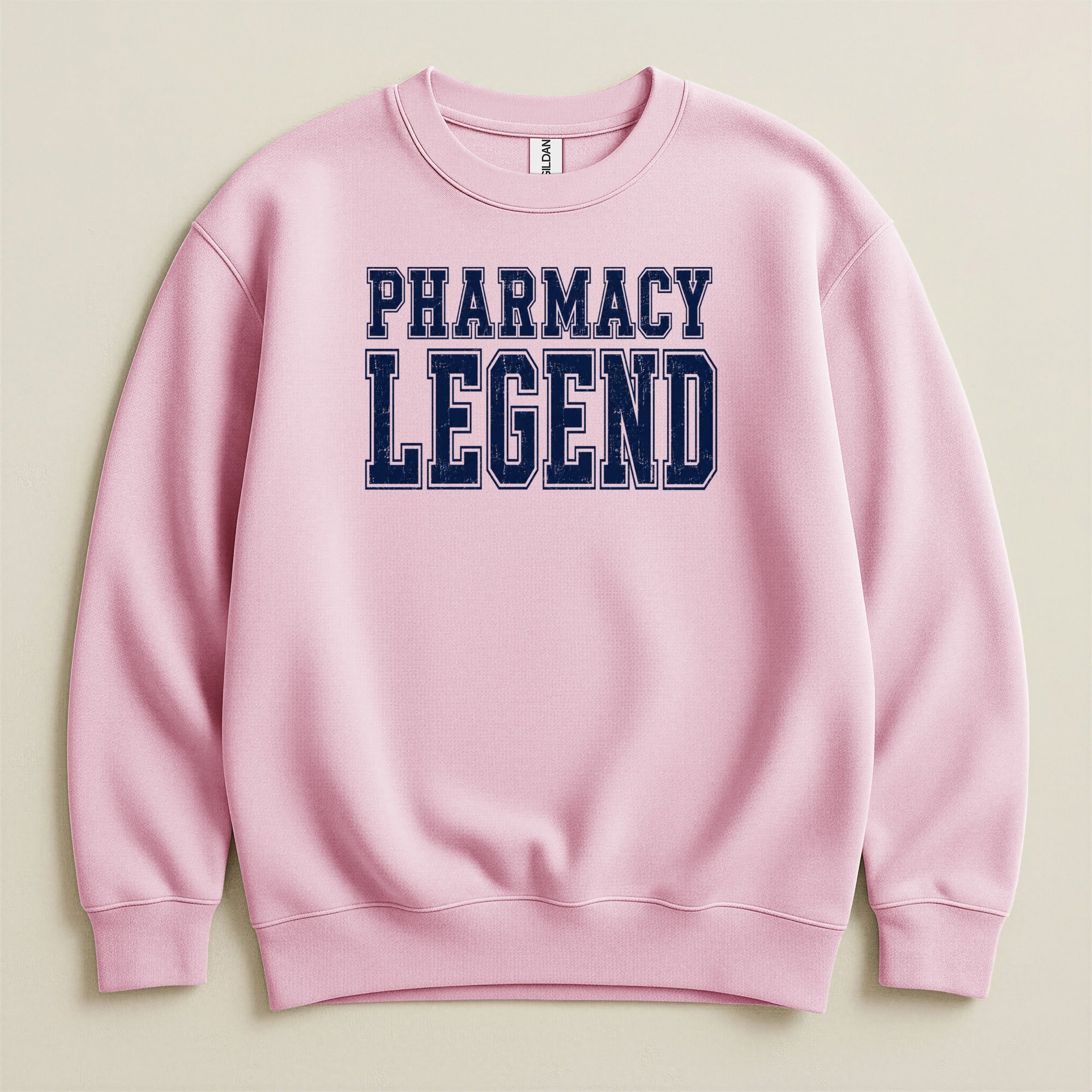 Pink sweatshirt with "PHARMACY LEGEND" text in navy blue lettering.