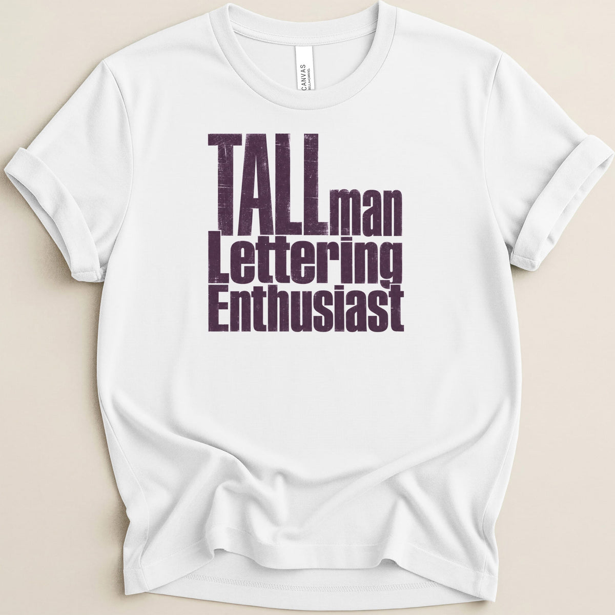 White t-shirt with distressed text "Tall man Lettering Enthusiast".