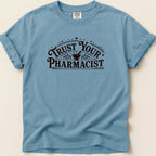 Blue t-shirt with "Trust Your Pharmacist" text in dark brown lettering.