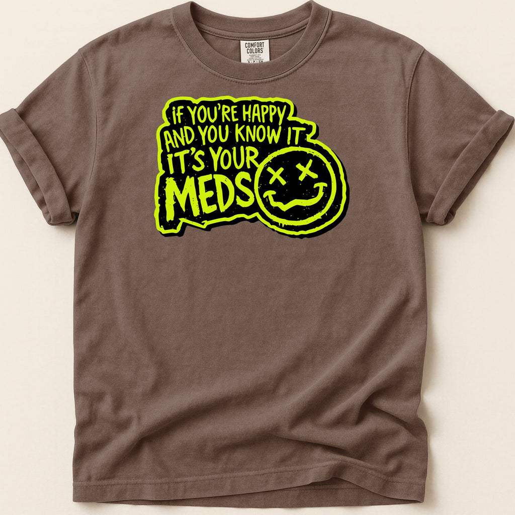 Brown t-shirt with neon yellow text "IF YOU'RE HAPPY AND YOU KNOW IT IT'S YOUR MEDS" and a smiley face.