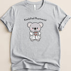 Grey t-shirt featuring a cartoon koala dressed as a pharmacist holding a prescription bottle.