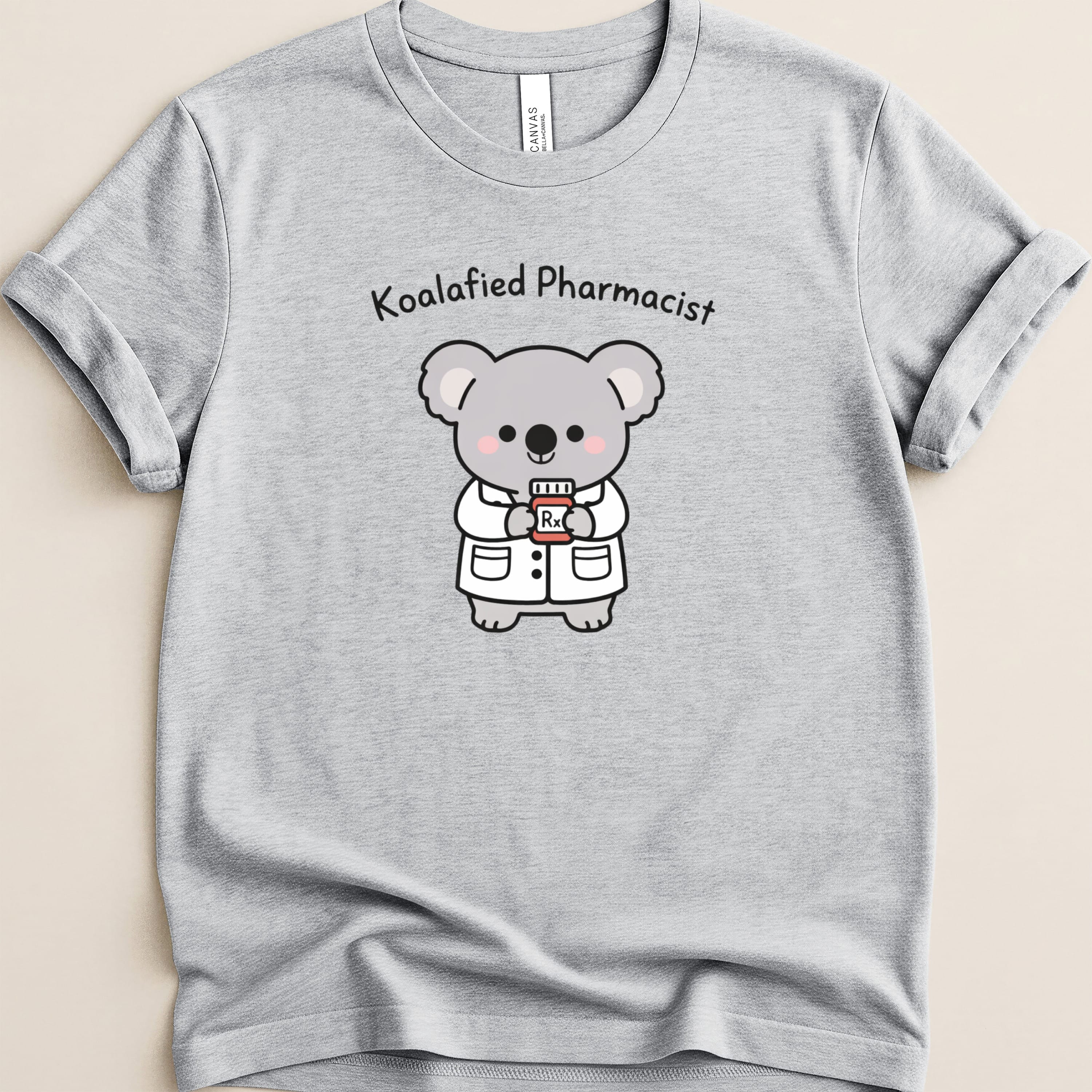 Grey t-shirt featuring a cartoon koala dressed as a pharmacist holding a prescription bottle.
