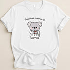 White t-shirt with cartoon koala pharmacist holding a prescription bottle.
