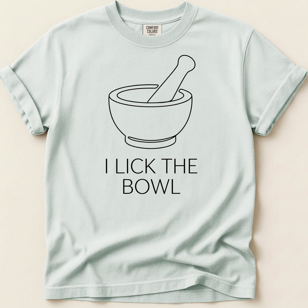 Light blue t-shirt with black line art of a mortar and pestle and text "I LICK THE BOWL".