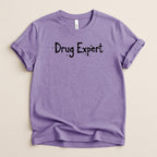 Purple t-shirt with "Drug Expert" text in black, distressed lettering.