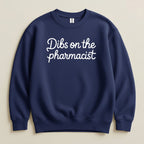 Navy sweatshirt with "Dibs on the pharmacist" text in white cursive.